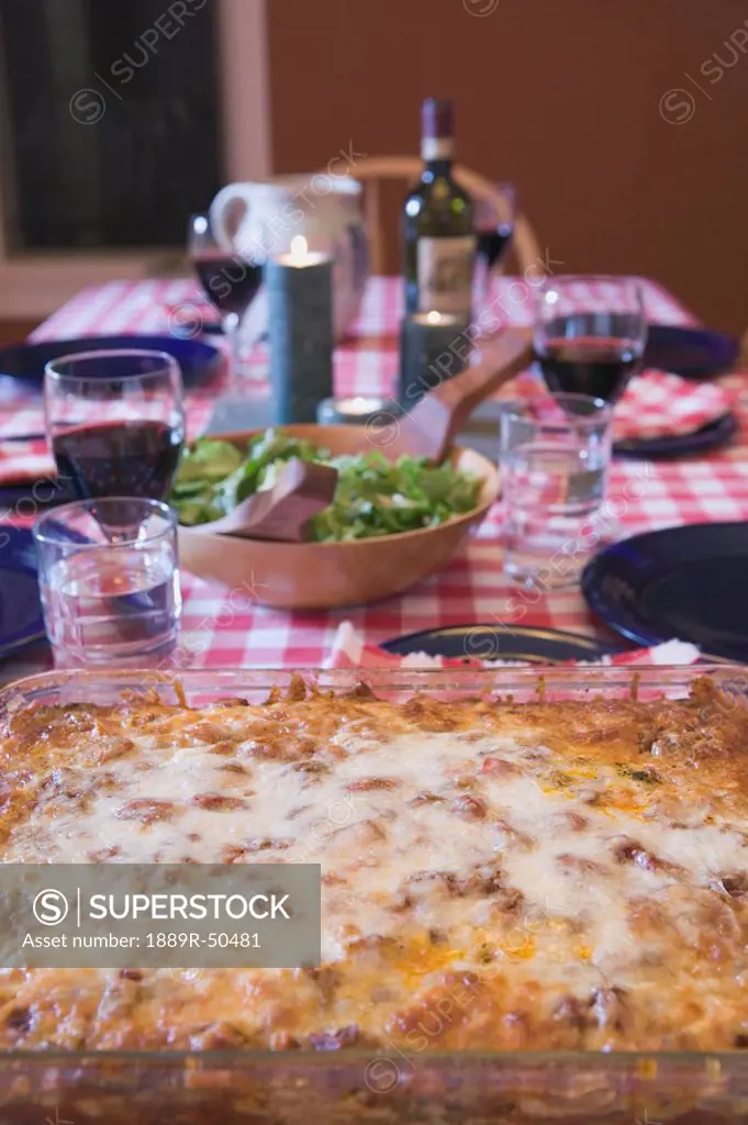 baked lasagna on a table set for dinner