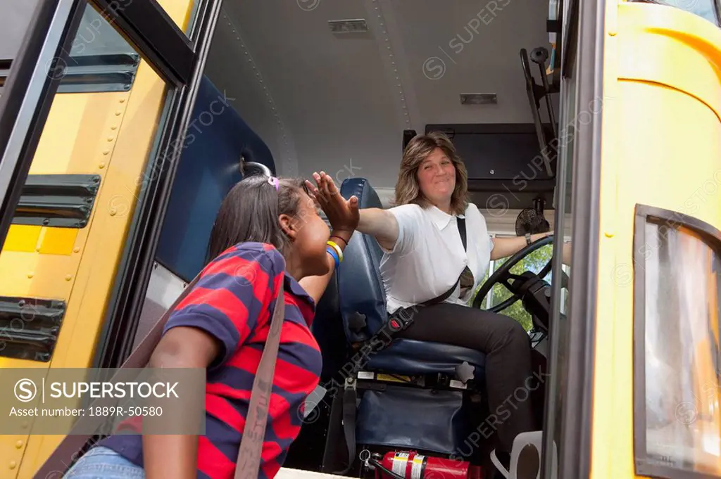 student and school bus driver slapping hands in a ´high five´