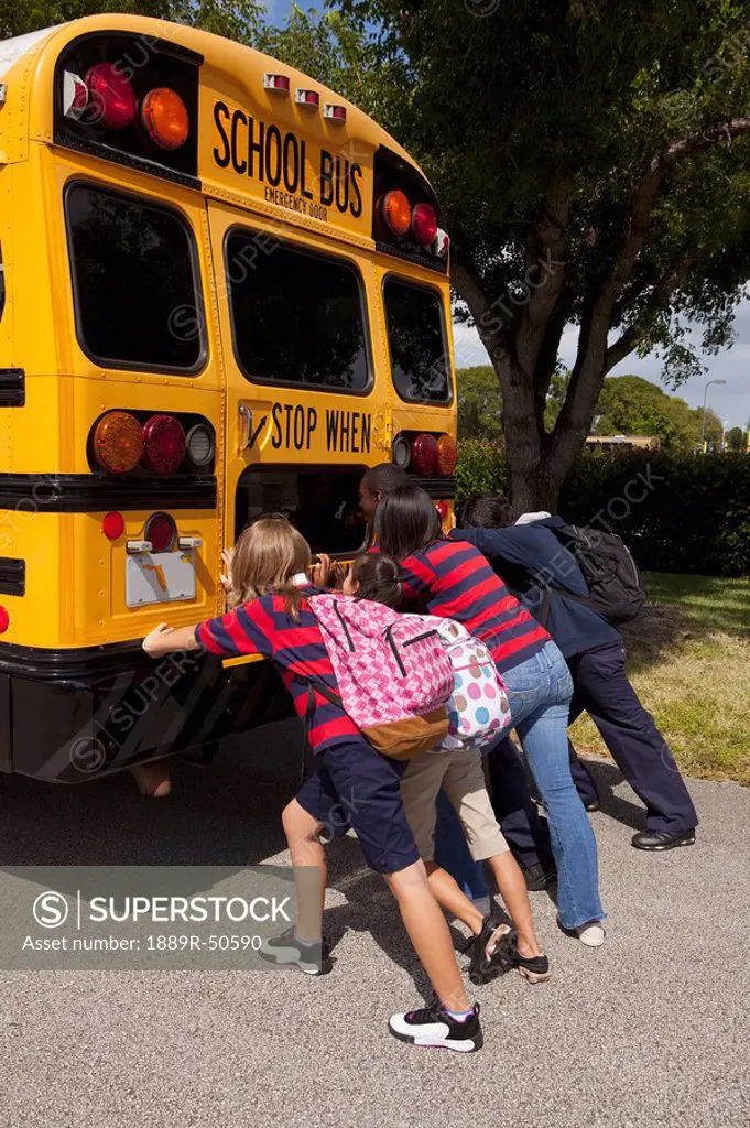 students pushing the back of the school bus