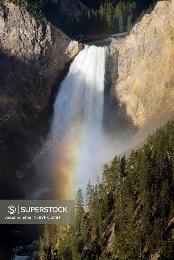 waterfall over cliff creating a rainbow