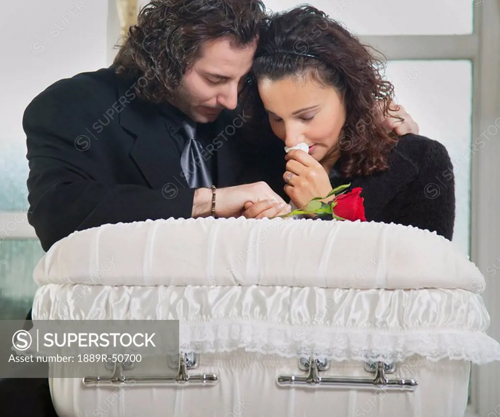 grieving couple with infant´s coffin