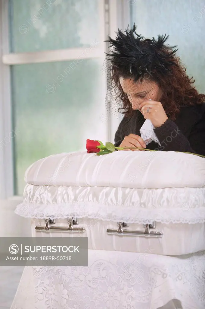 young mother grieving at an infant´s coffin