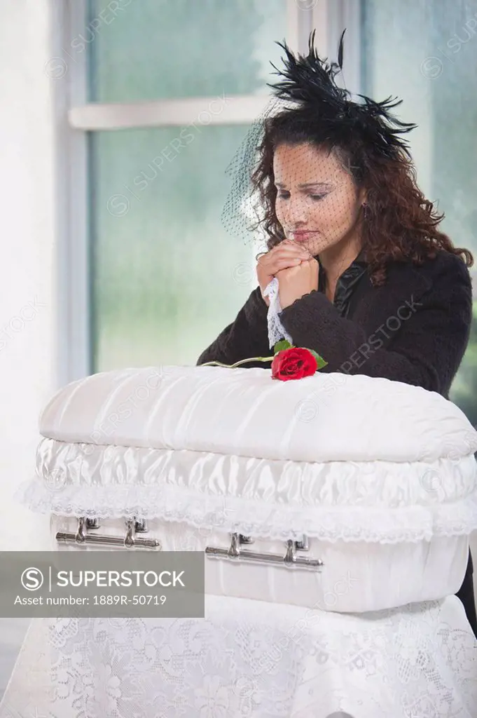 mother grieving at an infant´s coffin