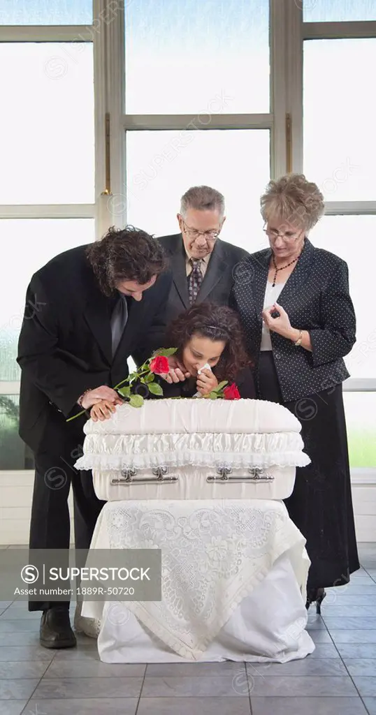 family grieving at an infant´s coffin
