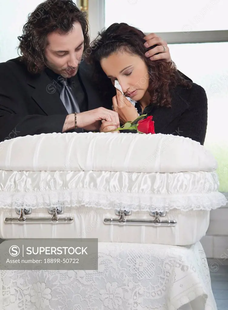 couple grieving at infant´s coffin