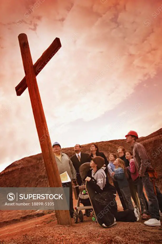 A small crowd gathered at a wooden cross
