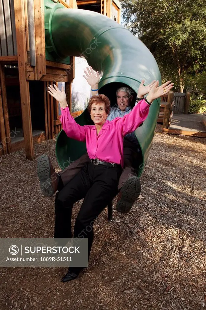 fort lauderdale, florida, united states of america, a couple sliding down a slide at the playground