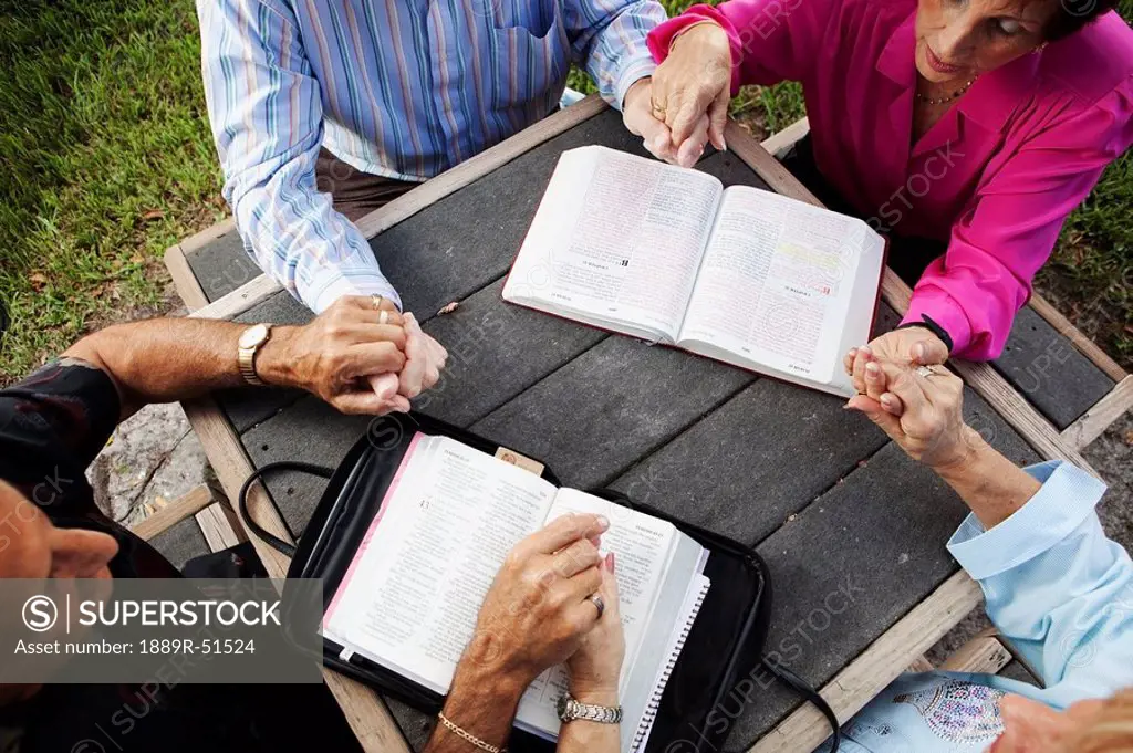fort lauderdale, florida, united states of america, two couples praying together with their bibles open
