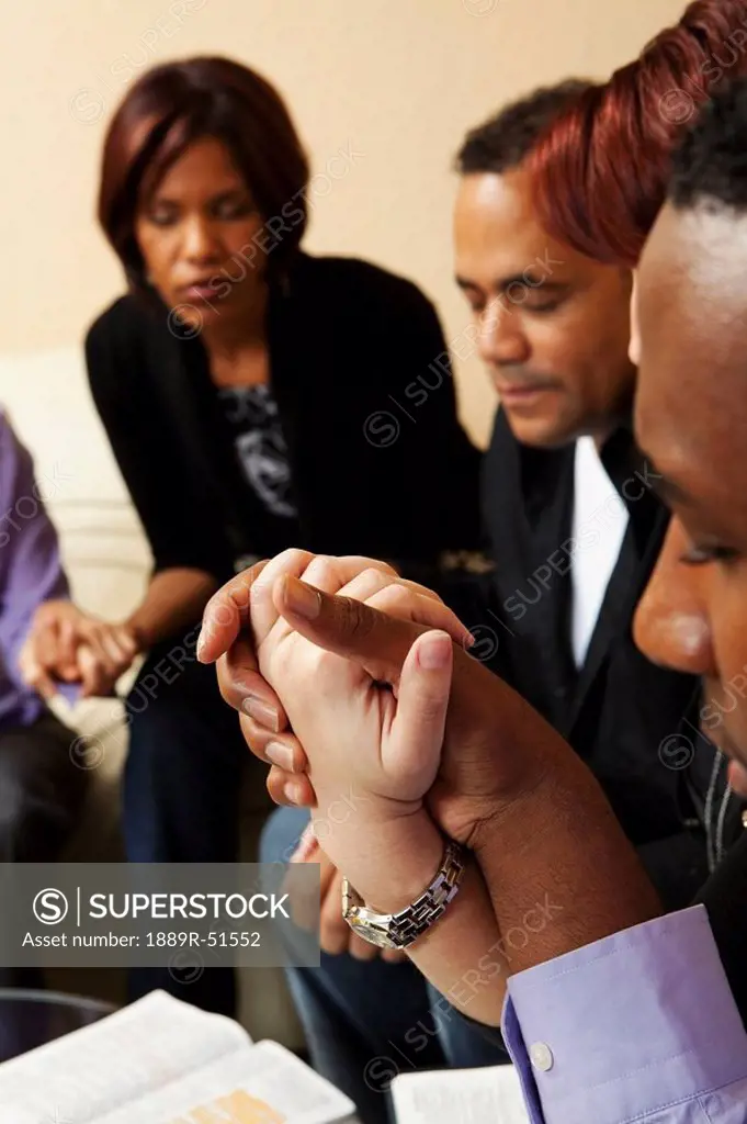 adults praying together with their bibles open