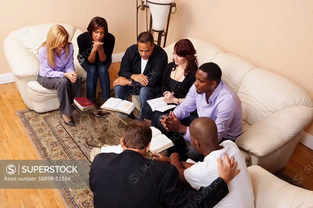 a group of adults praying with their bibles open