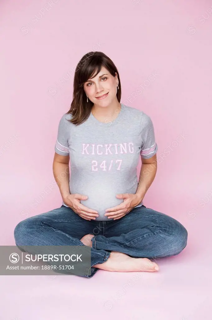 nashville, tennessee, united states of america, a pregnant woman sitting down with her hands on her belly
