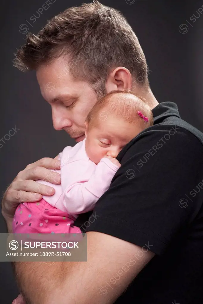 a father holds his infant daughter