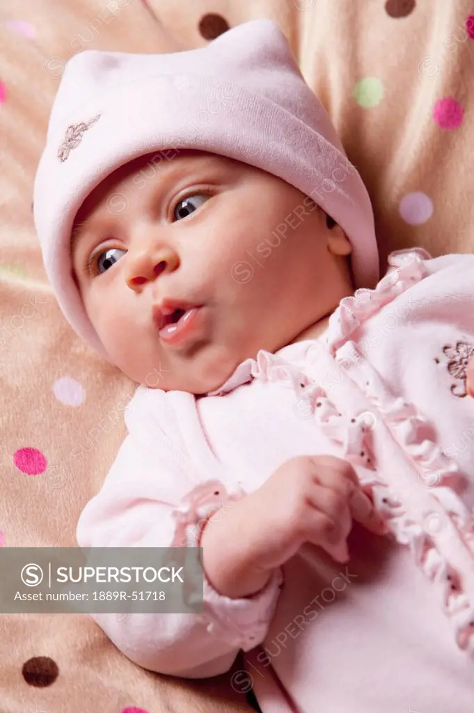 an infant girl with a surprised expression on her face