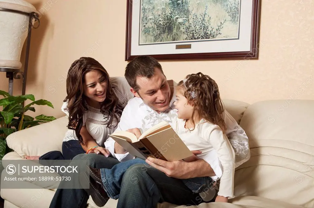 fort lauderdale, florida, united states of america, a mother and father reading a book to their daughter