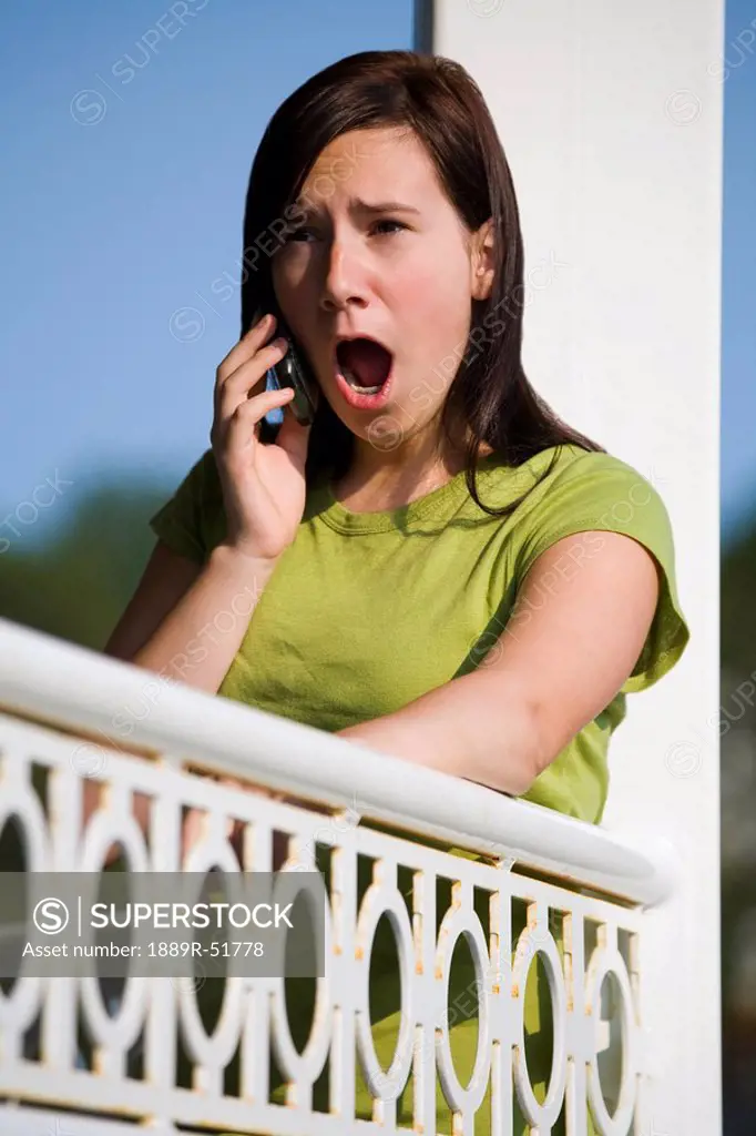 a girl talking on her cell phone with a surprised look