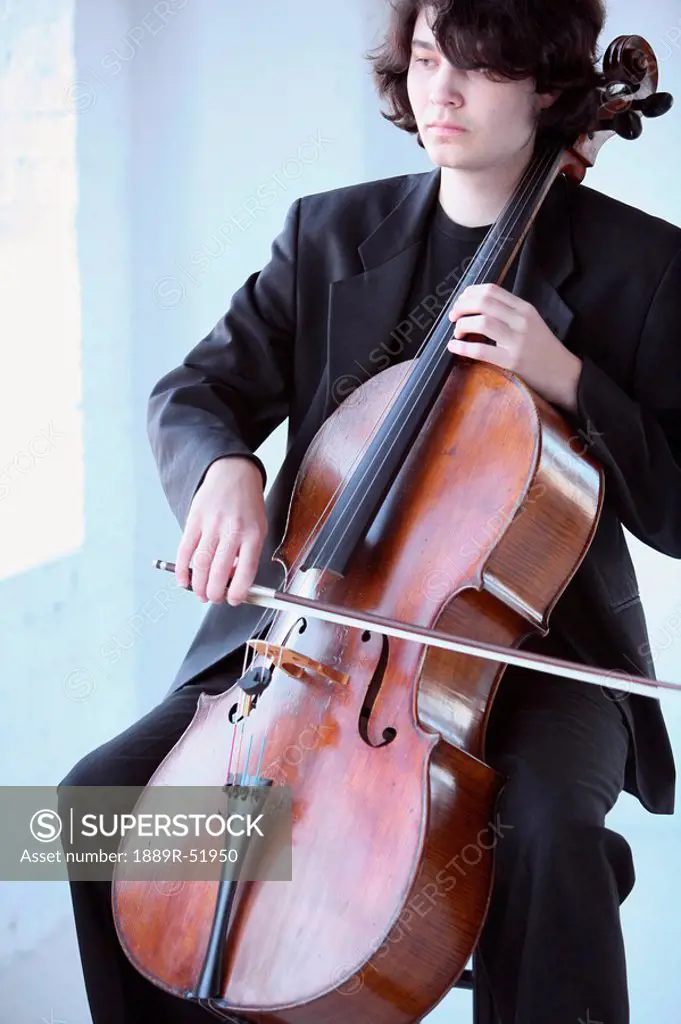 a young man playing a cello