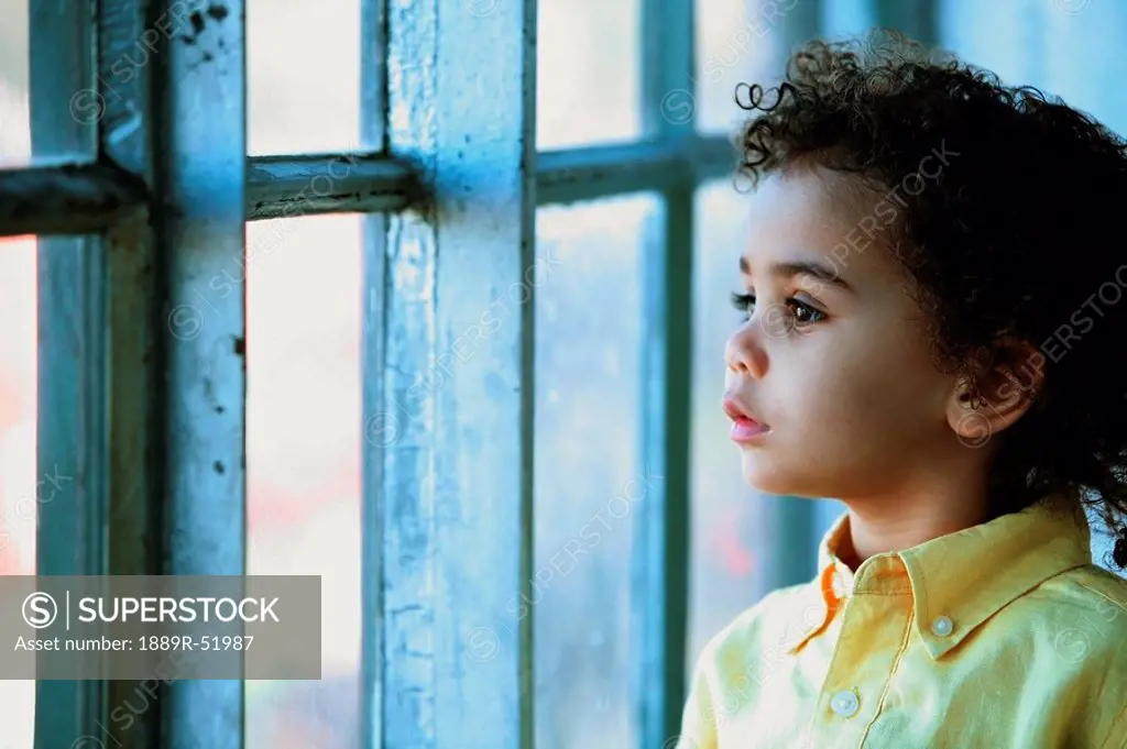 a young boy watching out the window