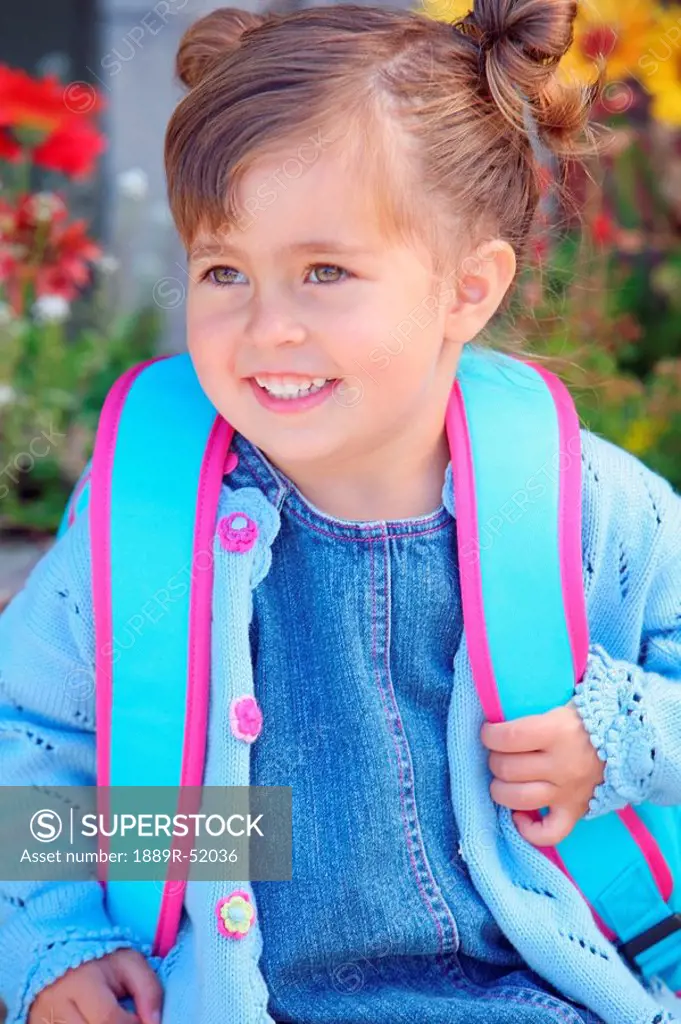 a young girl wearing a backpack