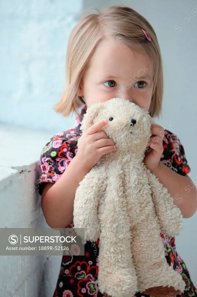 a young girl holding her teddy bear