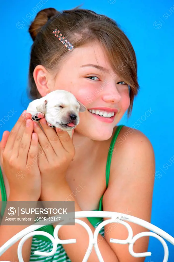 a girl holding a tiny puppy