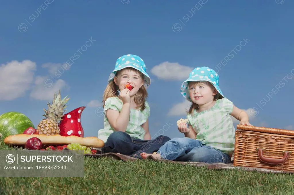 two young girls having a picnic