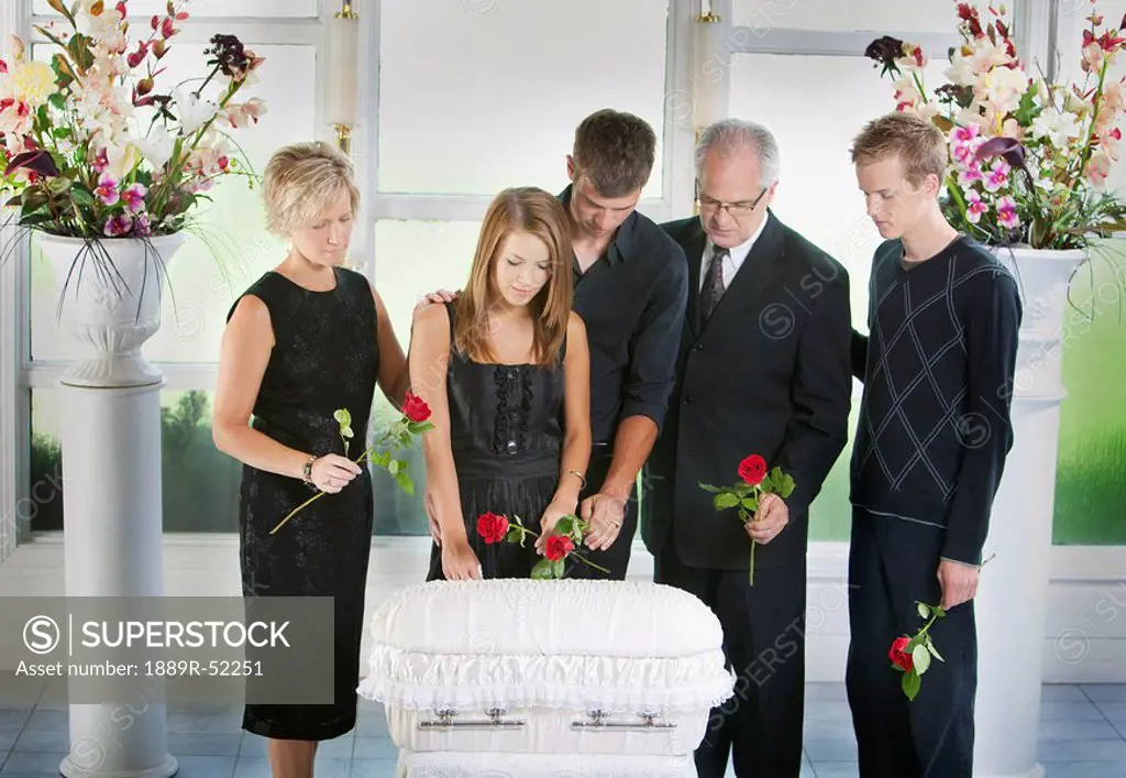 a family gathered around an infant´s coffin