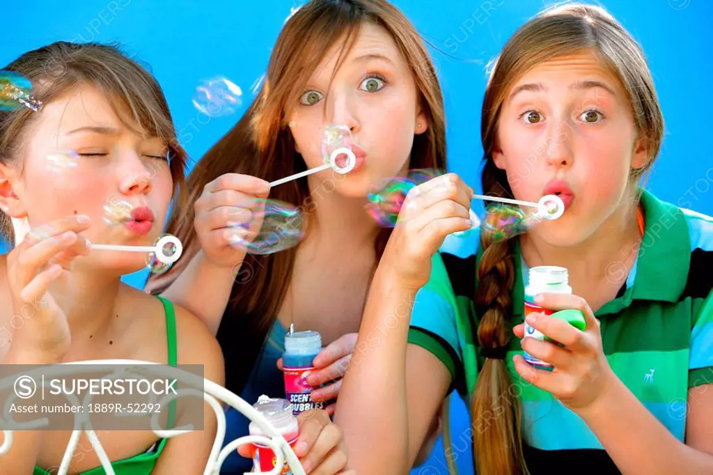 three friends blowing bubbles