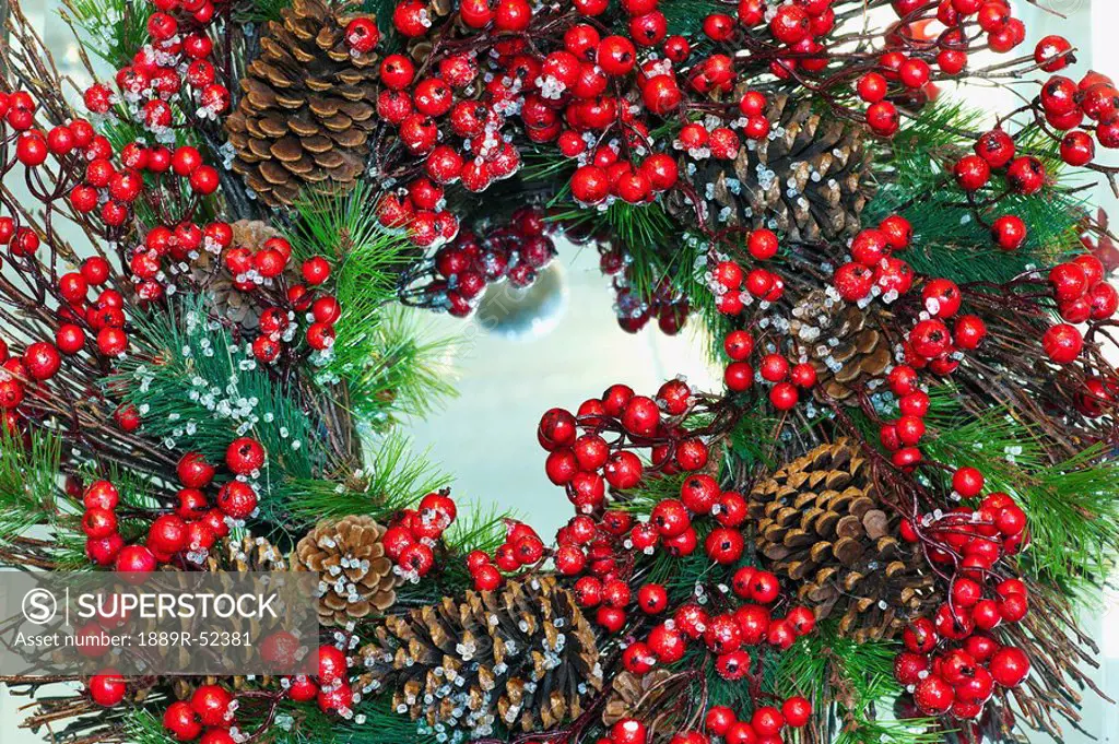 a christmas wreath with cranberries and pine cones