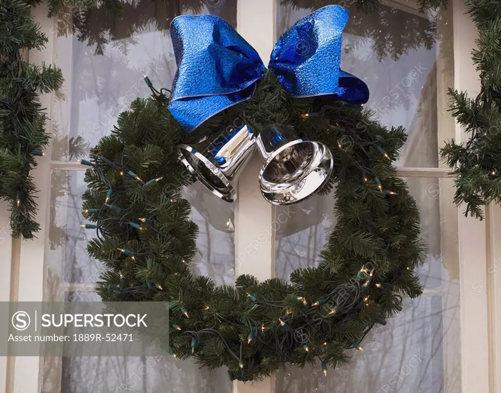 a wreath with silver bells and a blue bow