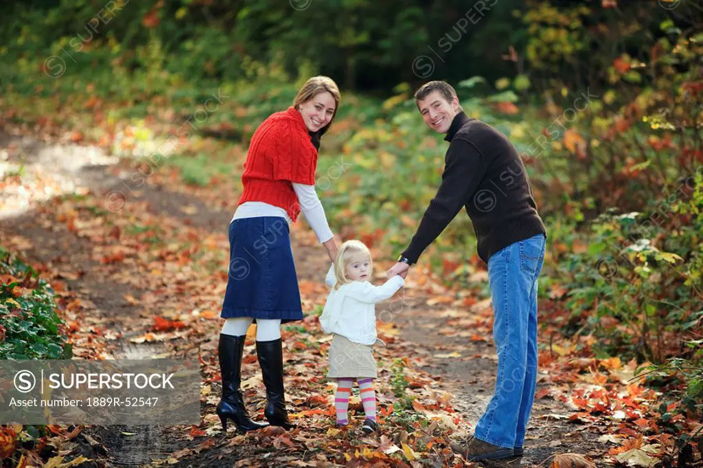 a family walking down a path in autumn