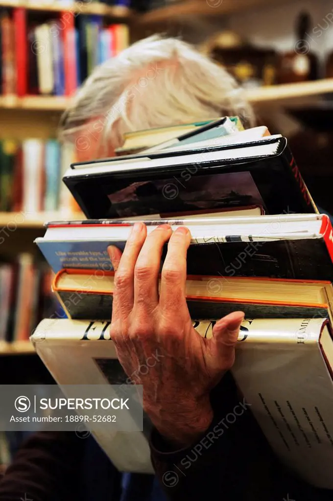 a man holding a pile of books
