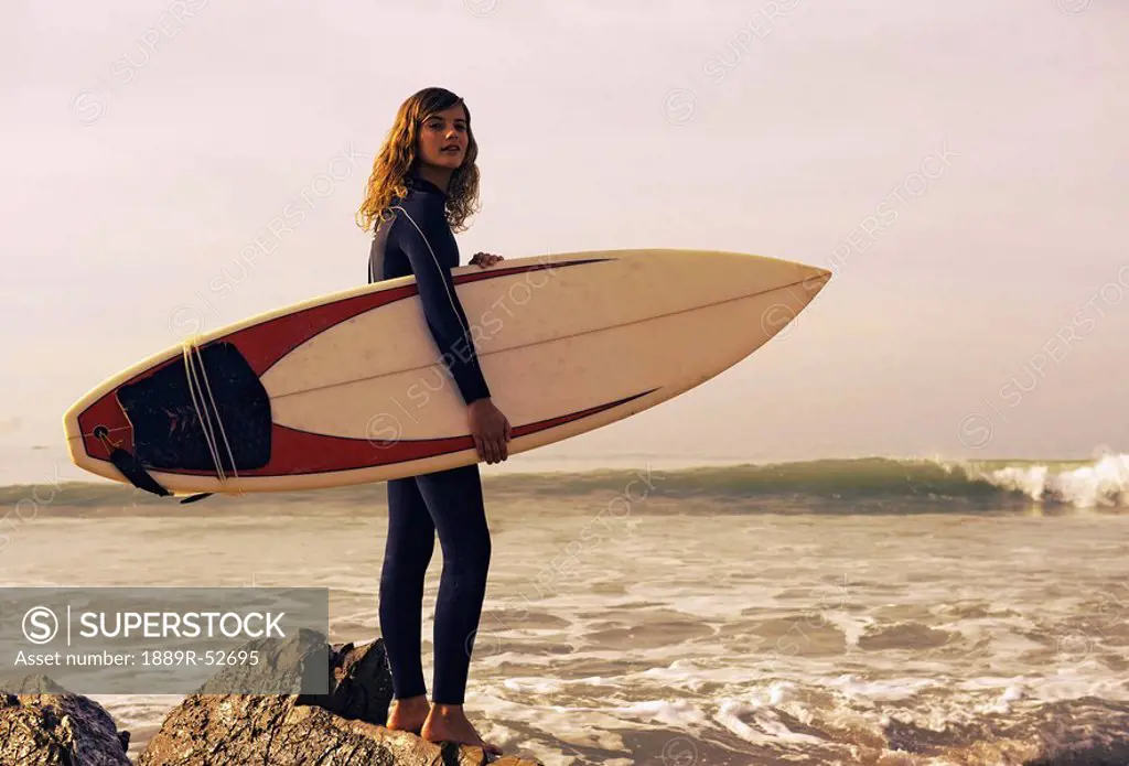 young woman with her surfboard at the beach