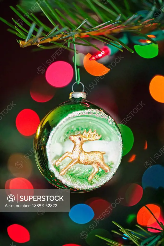 an ornament with a reindeer hanging from a christmas tree