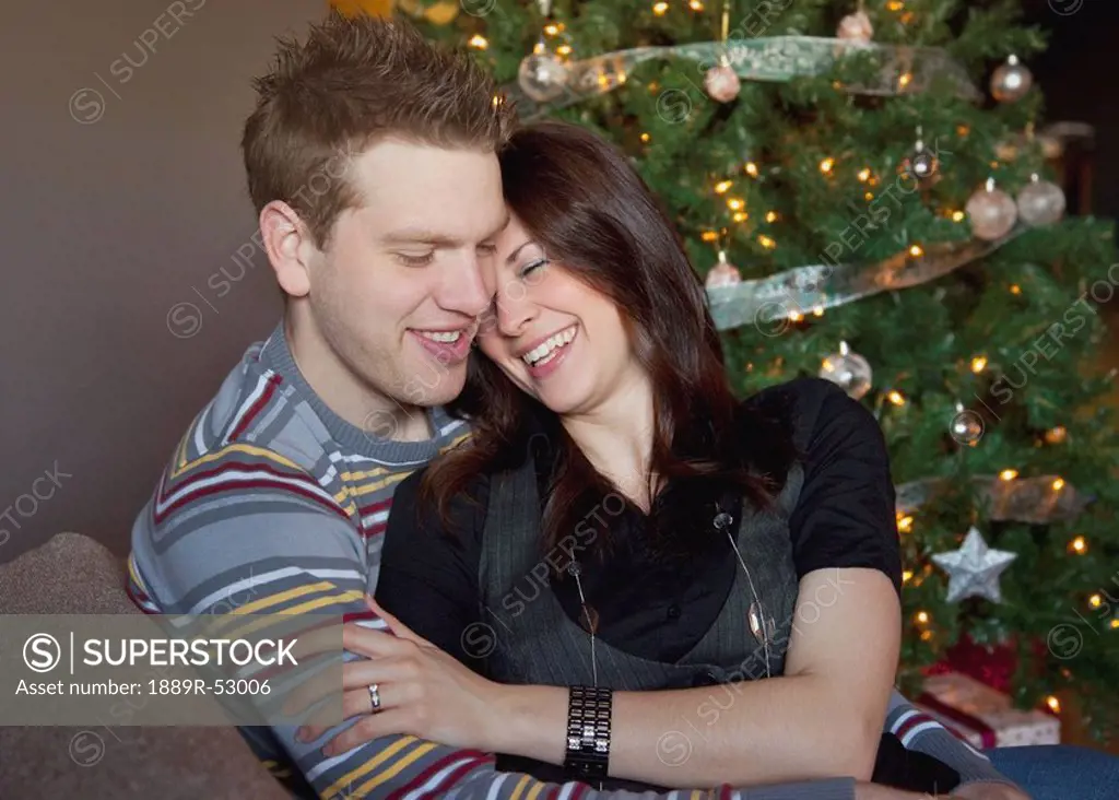 a couple by the christmas tree
