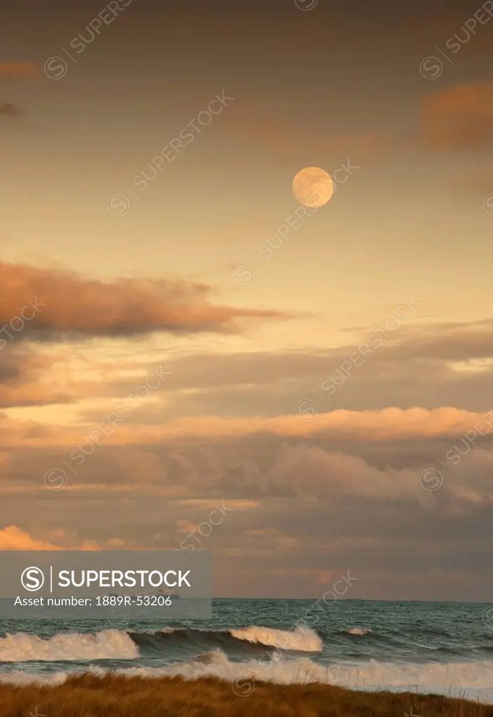 saltburn, teesside, england, a cargo ship traveling on the ocean with the moon in the sky