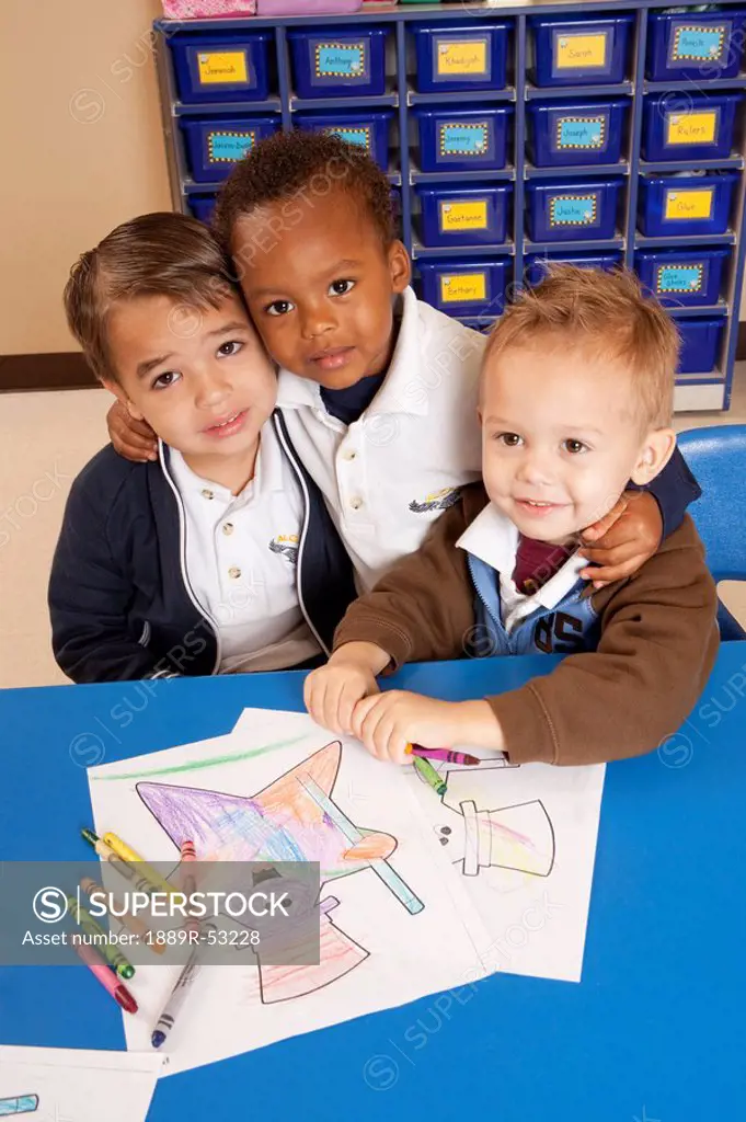 fort lauderdale, florida, united states of america, three young boys coloring at a table in a classroom
