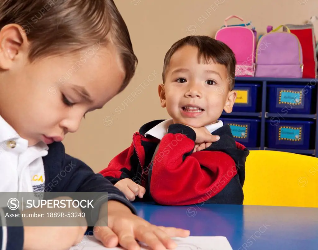 fort lauderdale, florida, united states of america, two young boys coloring at a table in a classroom