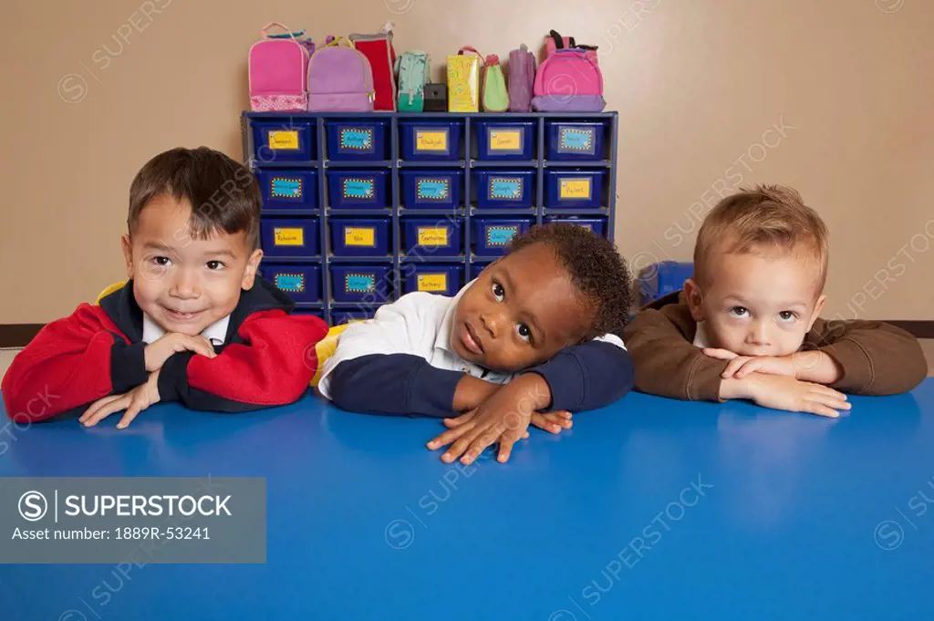 fort lauderdale, florida, united states of america, three young boys sitting at a table in a classroom