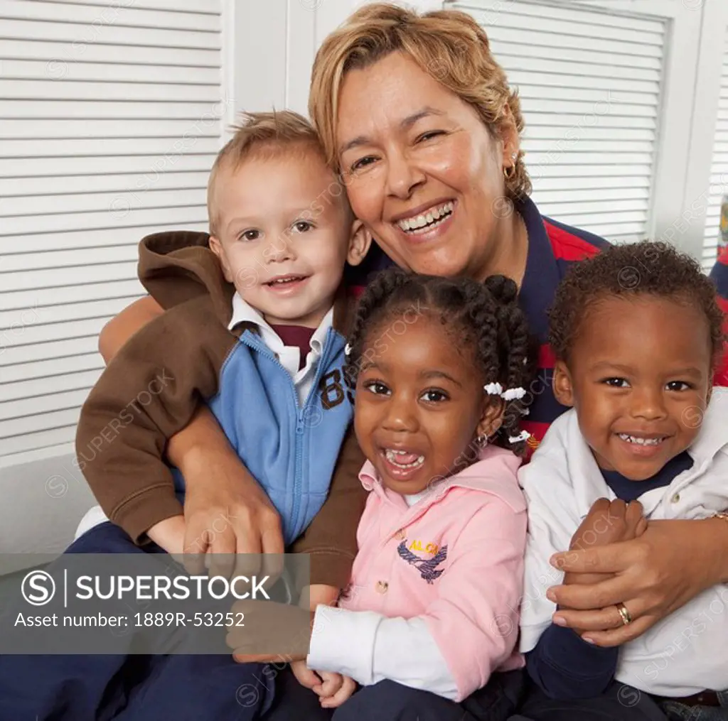 fort lauderdale, florida, united states of america, a teacher hugging three young children