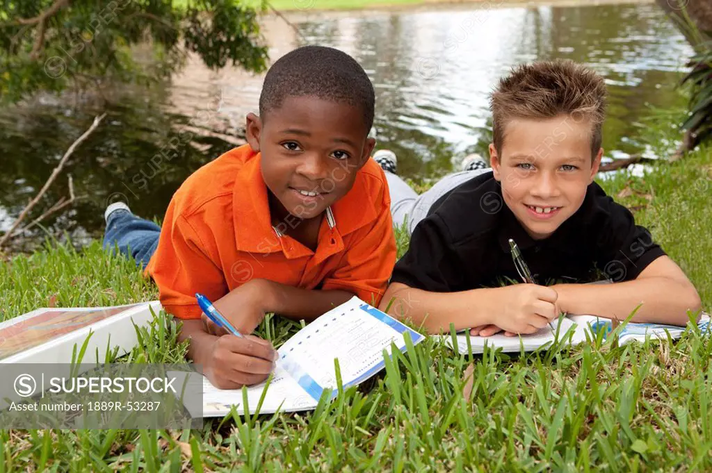 fort lauderdale, florida, united states of america, two boys doing school work in the park