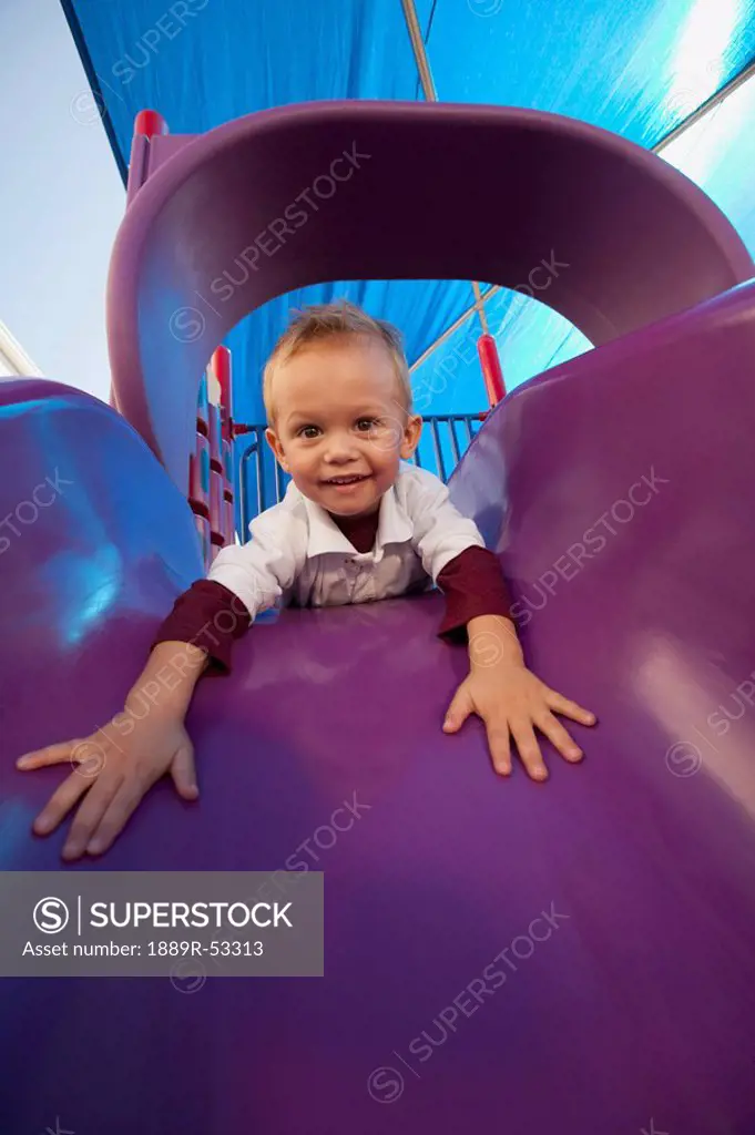 fort lauderdale, florida, united states of america, a young boy playing on a slide at the playground