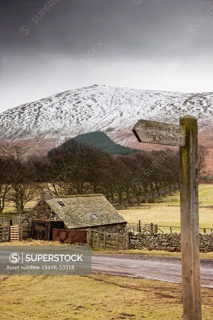 scottish borders, scotland, a shed along the road with a snow covered hill in the background