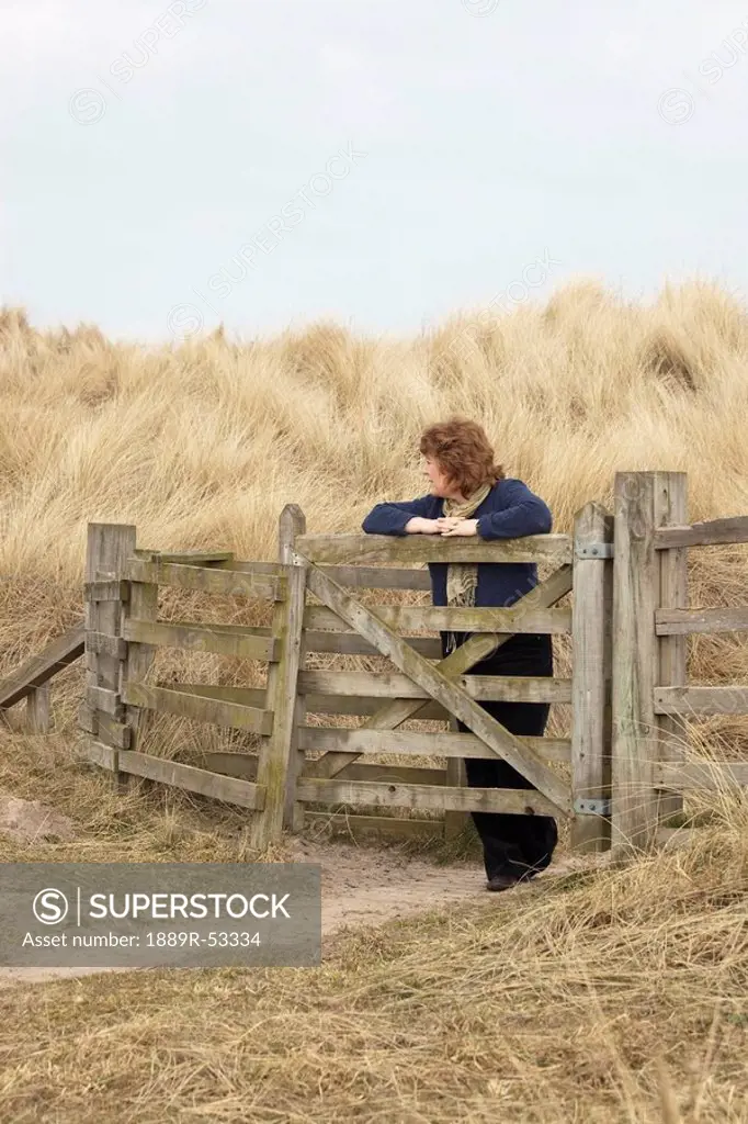 northumberland, england, a woman leaning against a fence