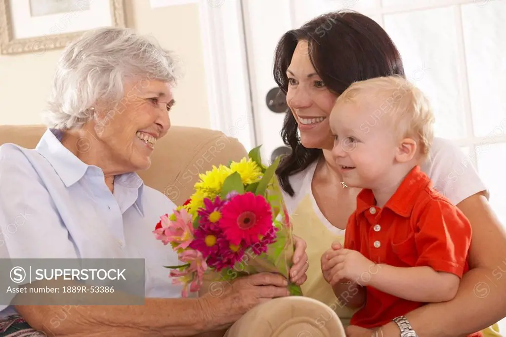 a young child giving flowers to his grandmother