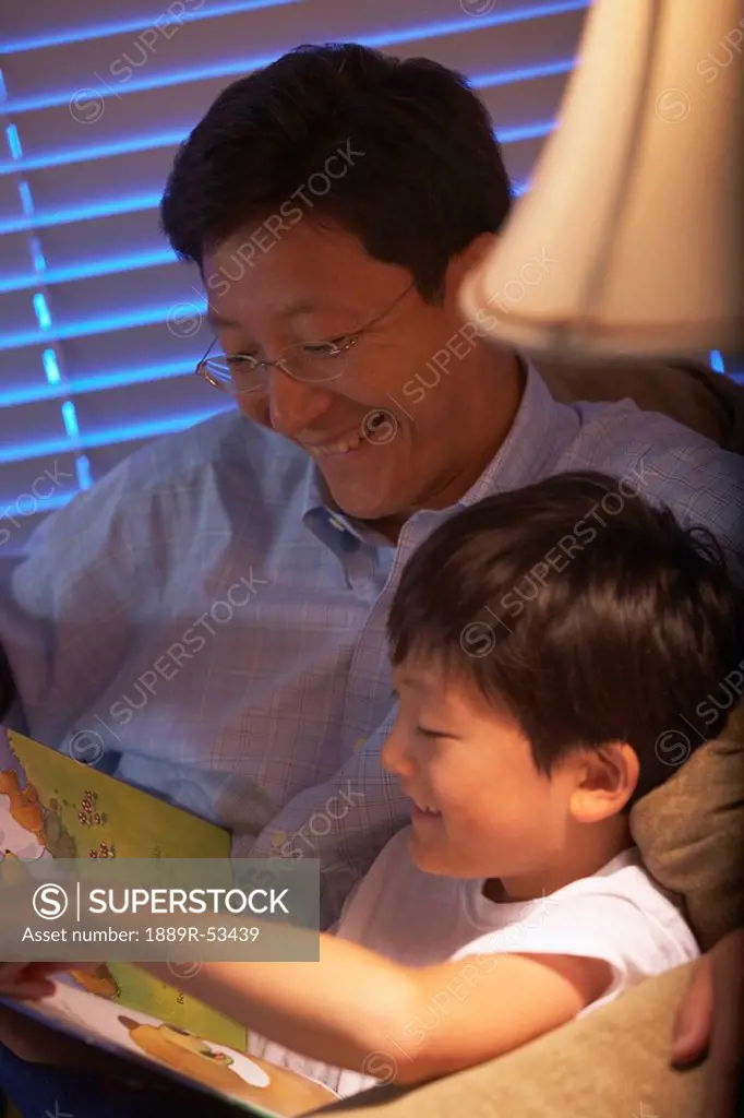 a father and son reading a book together