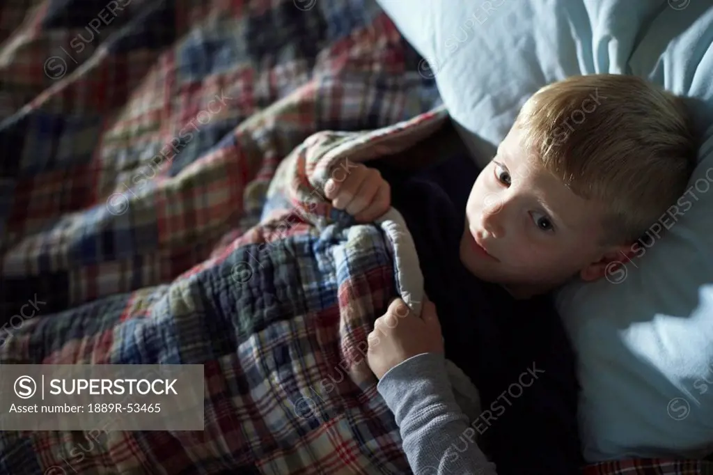 a boy laying awake in bed