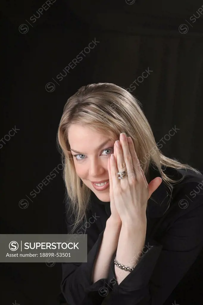portrait of a woman holding her hands up by her face