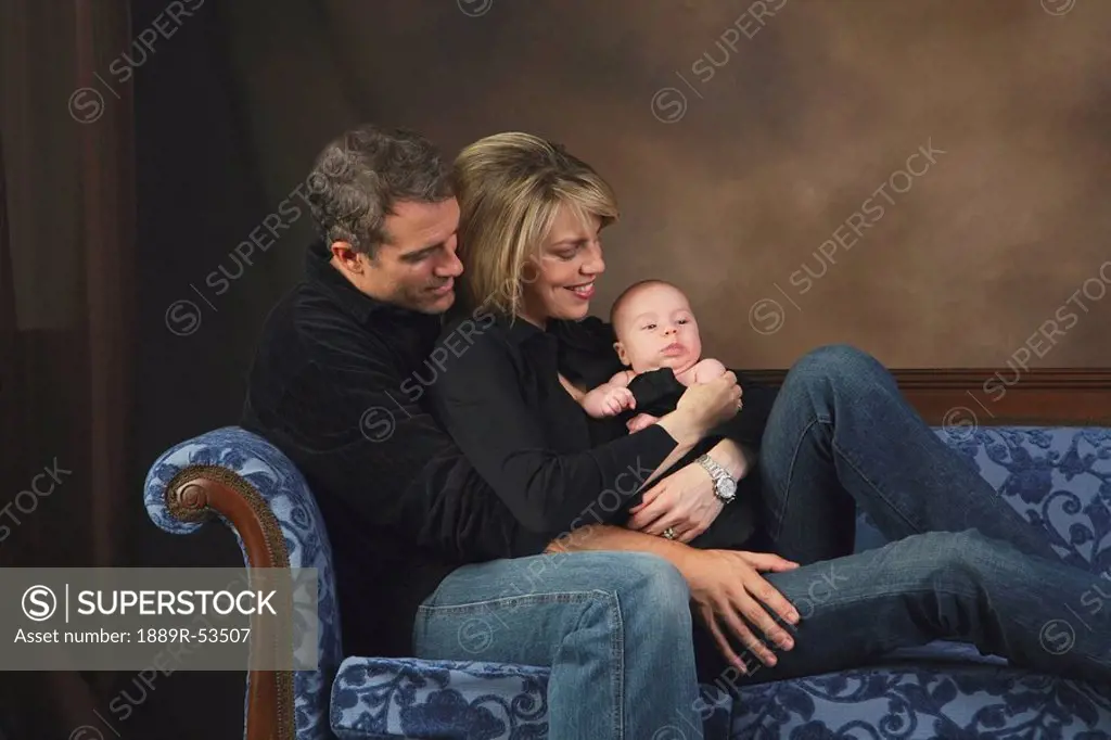 portrait of a couple with a baby on a couch
