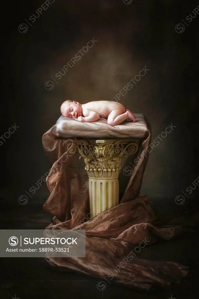 a baby asleep on a pillar