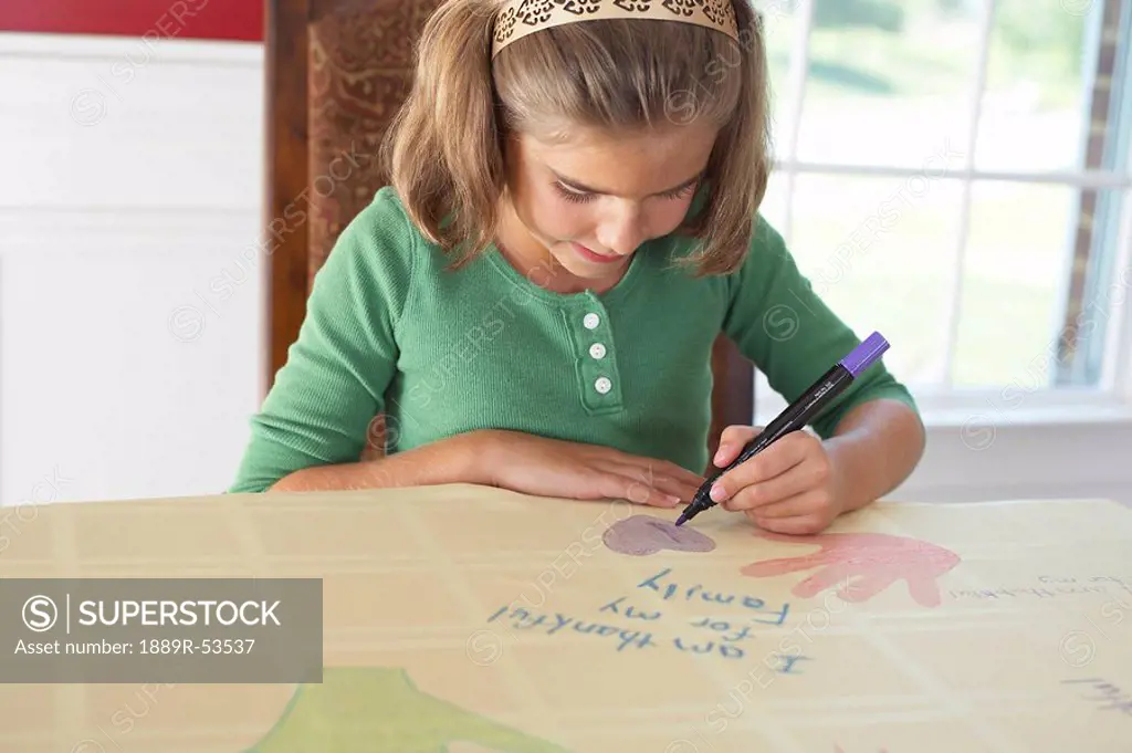 a girl drawing a picture saying ´i am thankful for my family´
